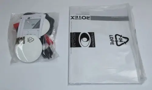 Zubehörbeutel mit Montageteilen, plastisch verpackt, enthält zwei weiße Platten, schwarze und rote Teile sowie eine Anleitung. Hinweis auf Recyclingmaterialien vorhanden. Produkt von Daikin.